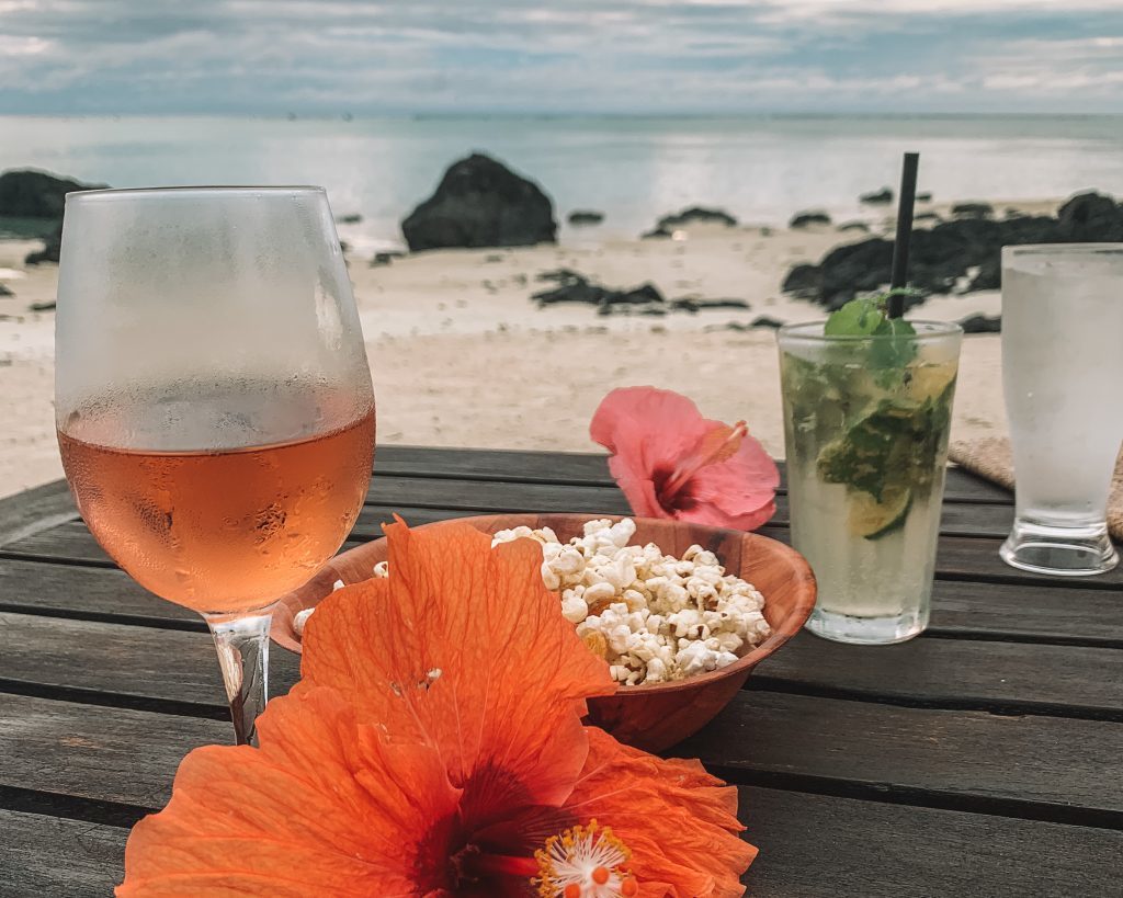 the cook island beach with wine, popcorn, and tropical flowers
