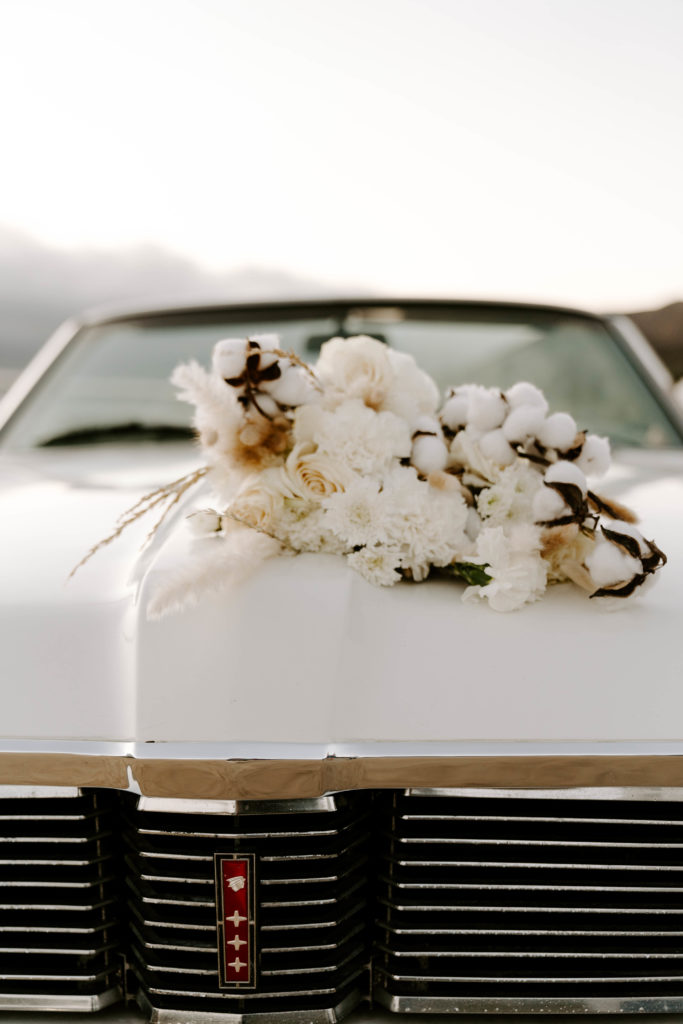 Floral Arrangement on top of old chevy car - Are destination weddings selfish?