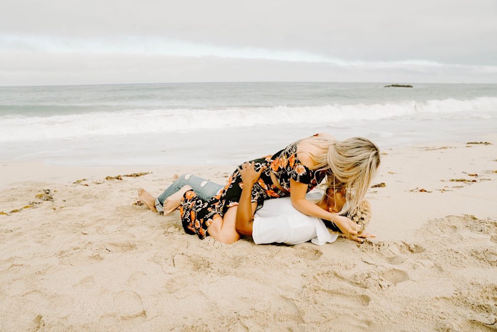 couple playing in the sand at garapata state beach california