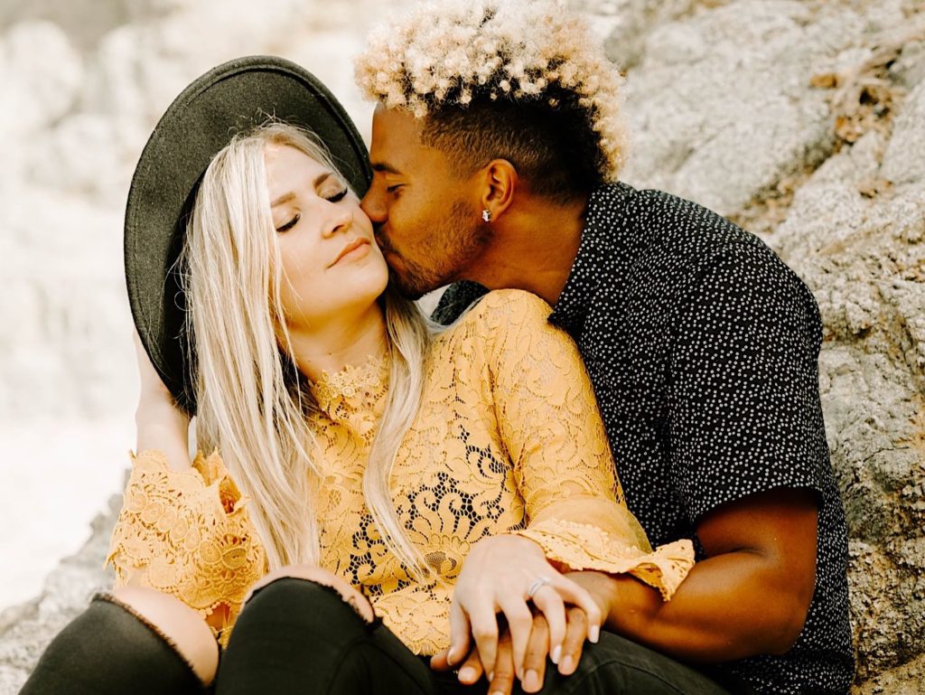 guy kissing girl's cheek at garapata beach in big sur