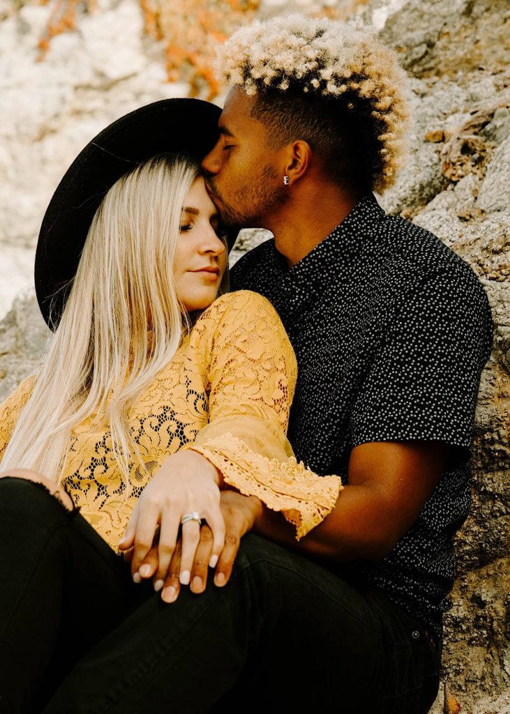 guy kissing girl's forehead at garapata beach in big sur