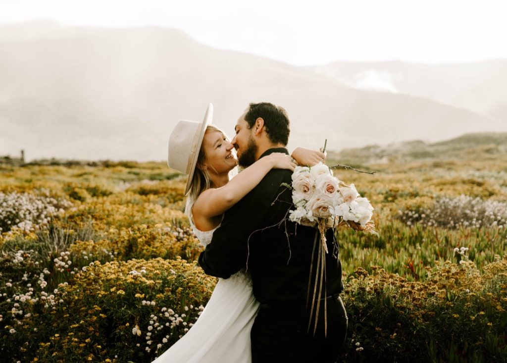 couple embracing about to kiss cliff side elopement big sur