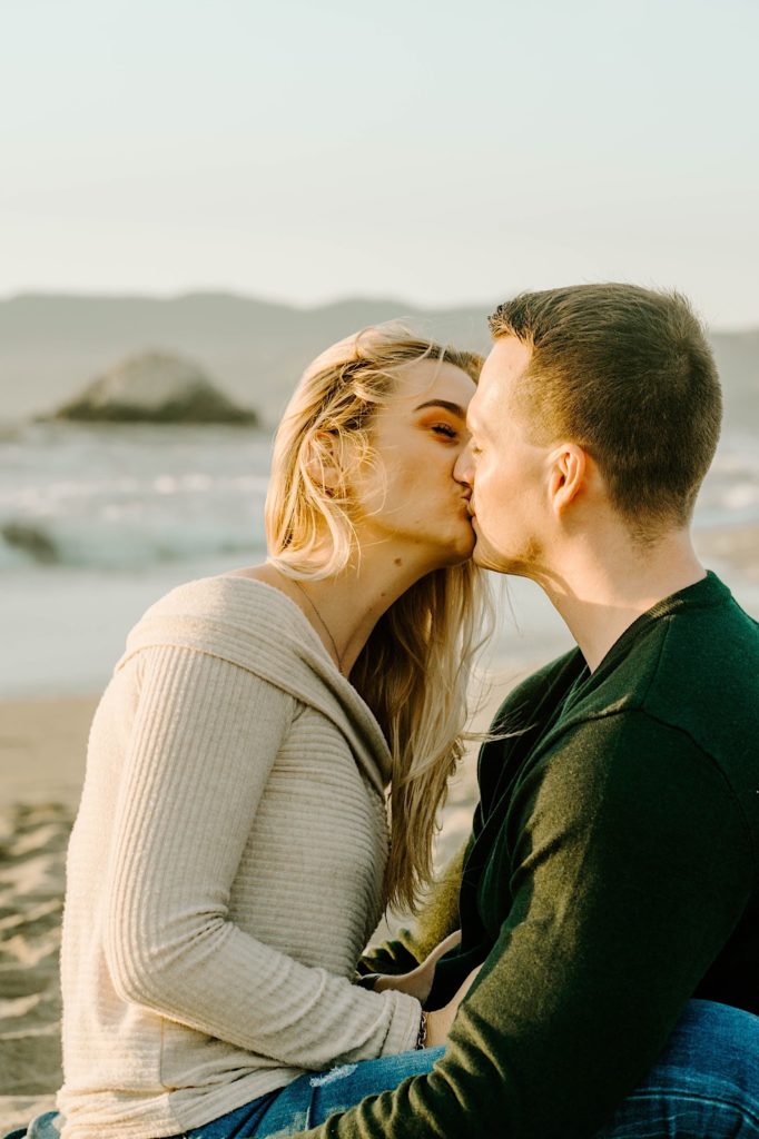 couple sitting kissing each other ocean beach san francisco