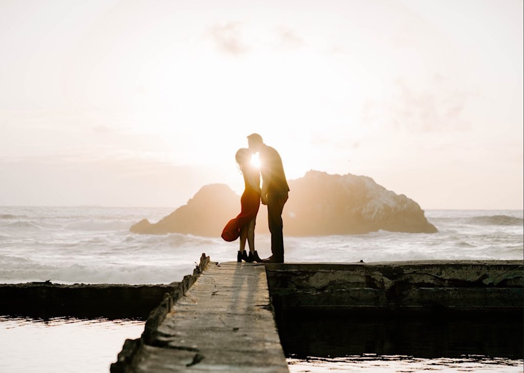 couple kissing at sutro baths in san francisco