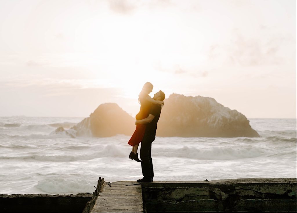 guy holding girl at sutro bath in san francisco