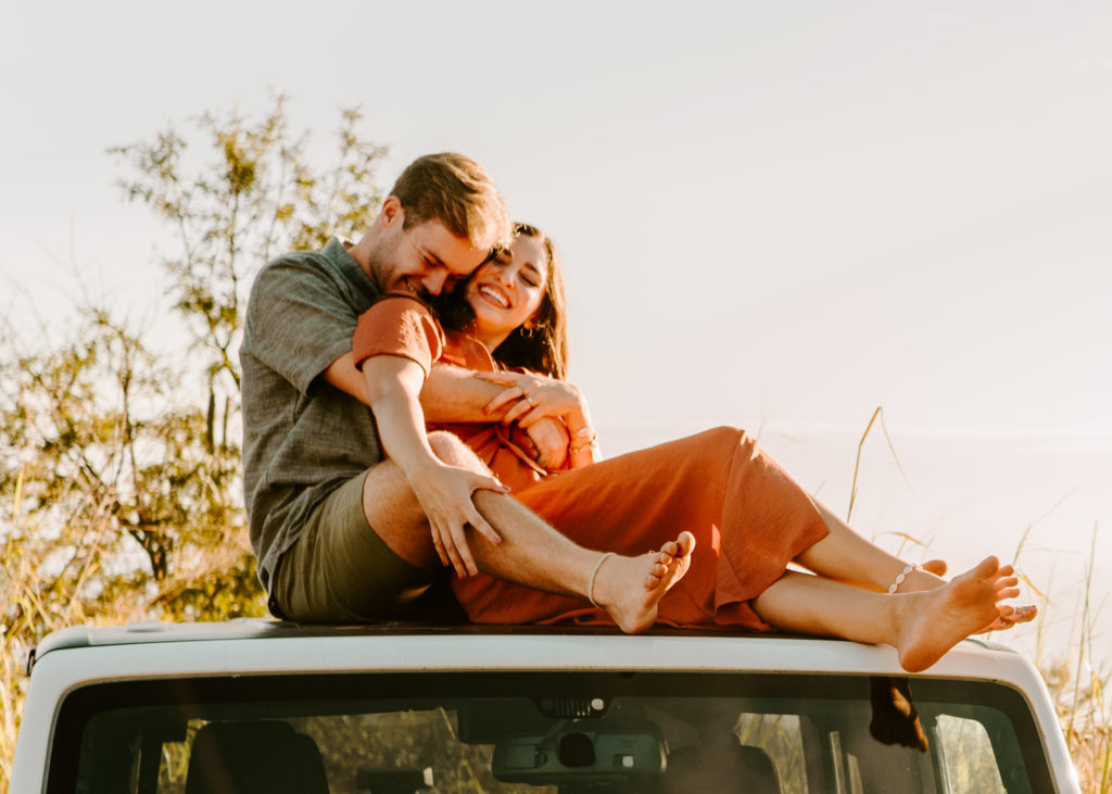 Couples engagement session - brooke and benson sitting on a jeep cuddling