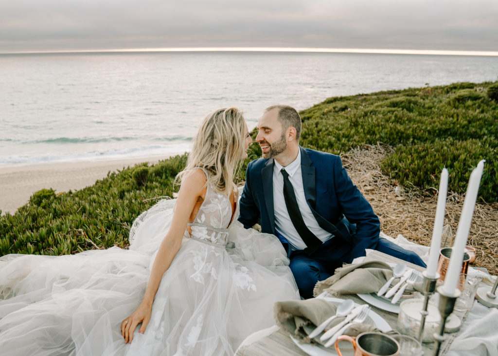 couple elopement in Big Sur, California cliff side looking at each other