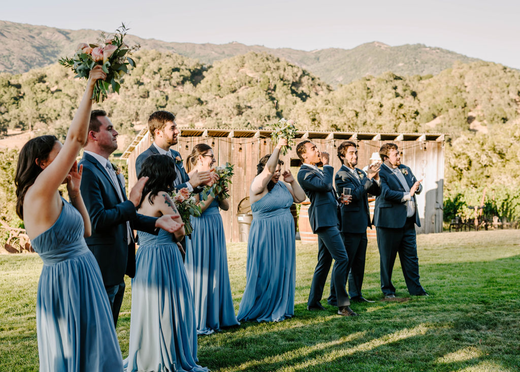 wedding party cheering new married couple in - 21 questions to ask your photographer