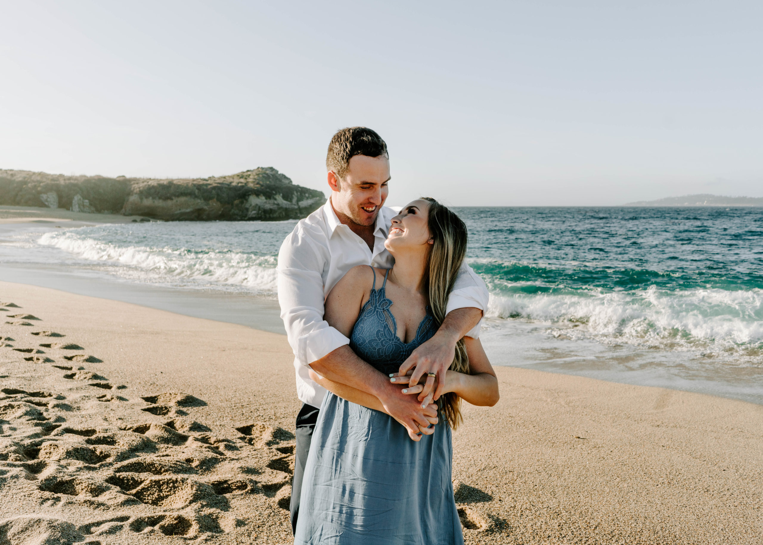 Guy hugging girl from behind during Big Sur engagement photos
