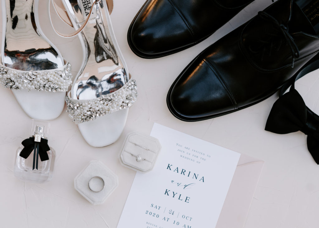 Bride and groom's shoes with rings and invitation