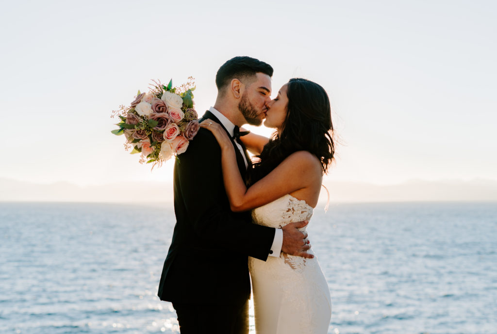 Bride and groom kissing in front of Lake Tahoe.