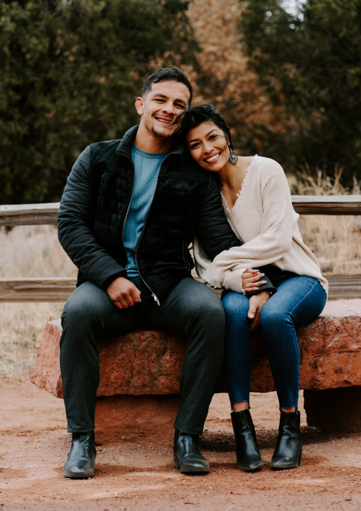 Couple smiling while sitting in Garden of the Gods.
