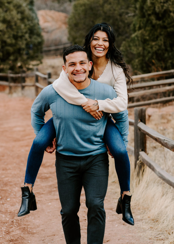 Guy giving girlfriend a piggy back ride.