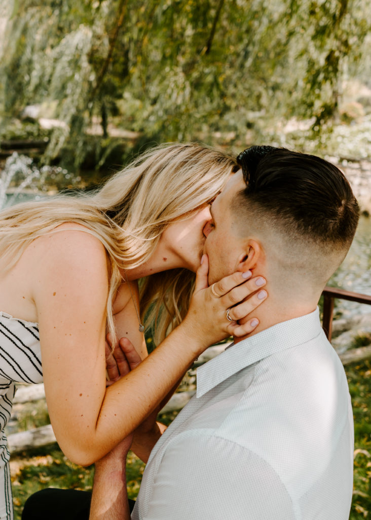 Woman kissing man after wedding proposal.