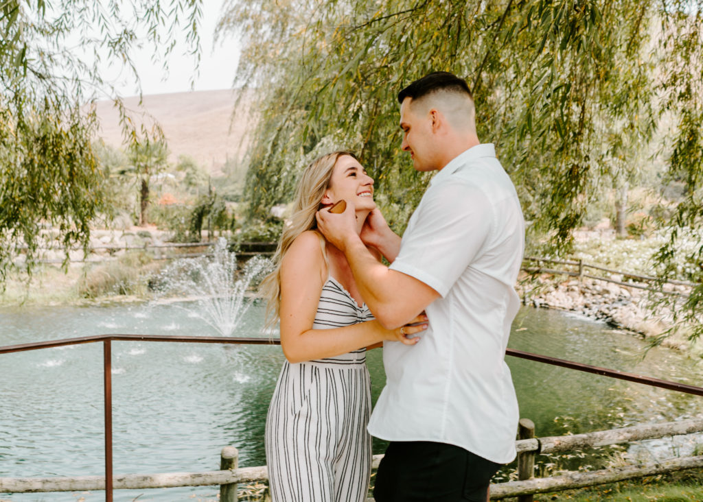 Couple smiling at each at Nella Terra Cellars in Sunol, CA.