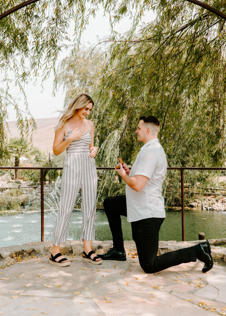 Man down one knee asking his girlfriend to marry him.