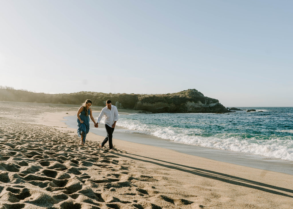 couple walking on beach for Big Sur engagement photos