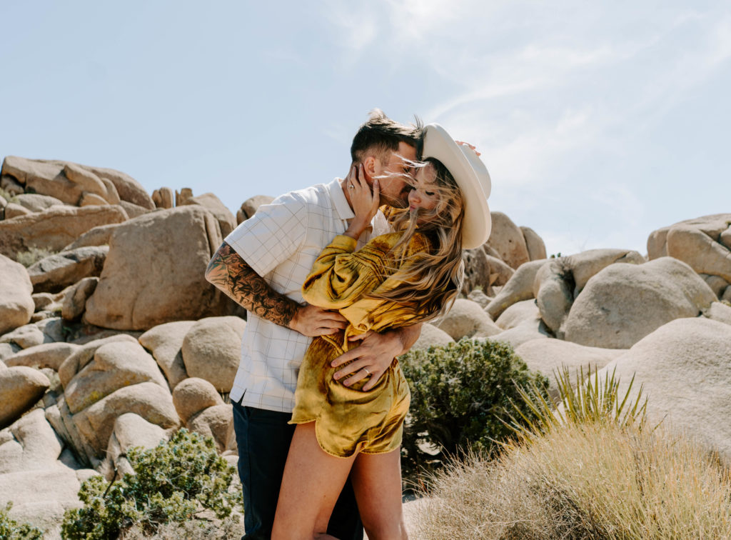 Man kissing woman's cheek in the desert.