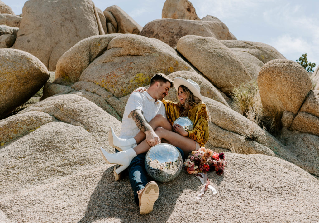 Man and woman laughing while sitting on Jumbo Rocks.