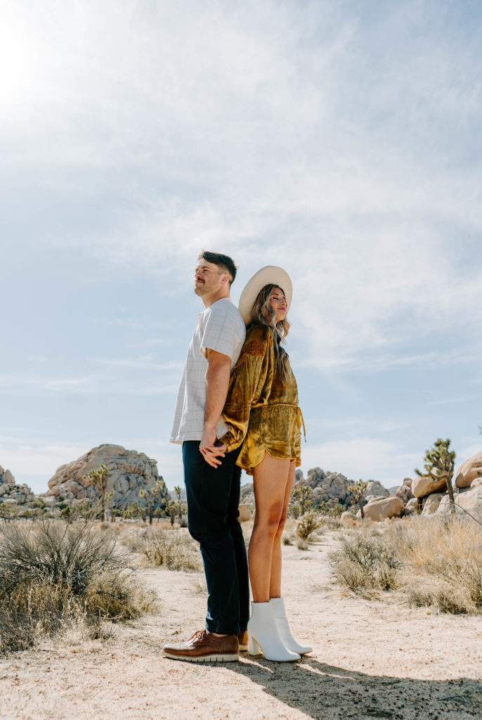 Woman and man back to back in Joshua Tree.