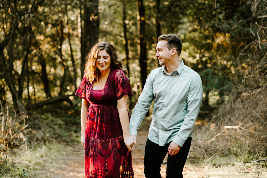 couple laughing while walking in the Redwoods