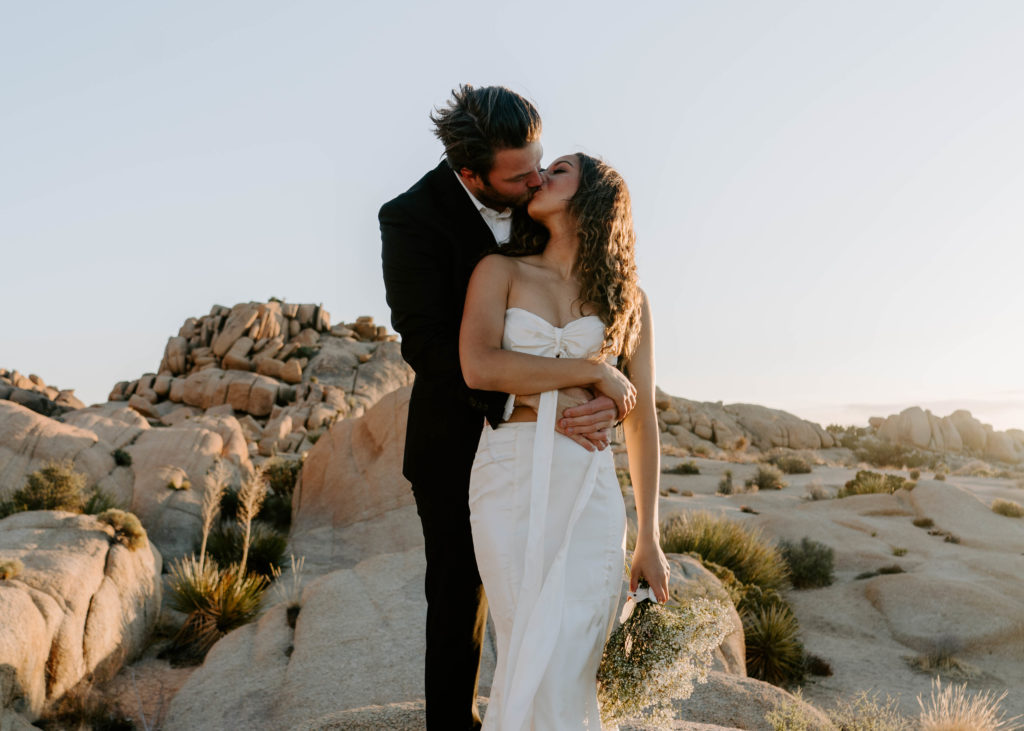 Brie and groom kissing during their Joshua Tree wedding.