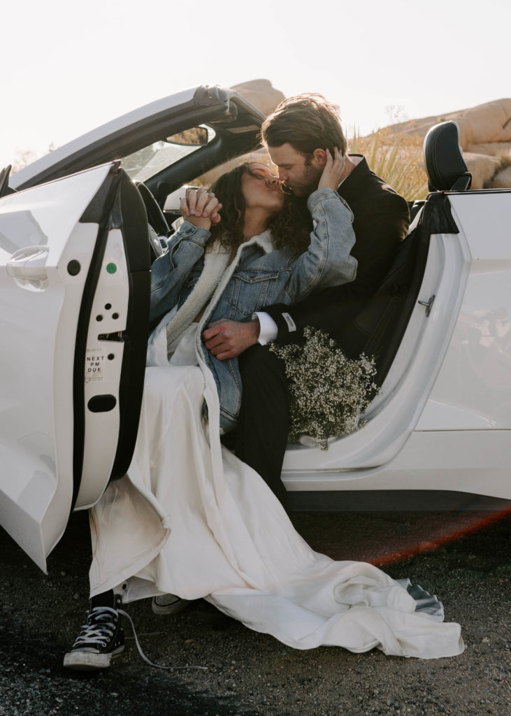 Bride and groom almost kissing while sitting in a Mustang.