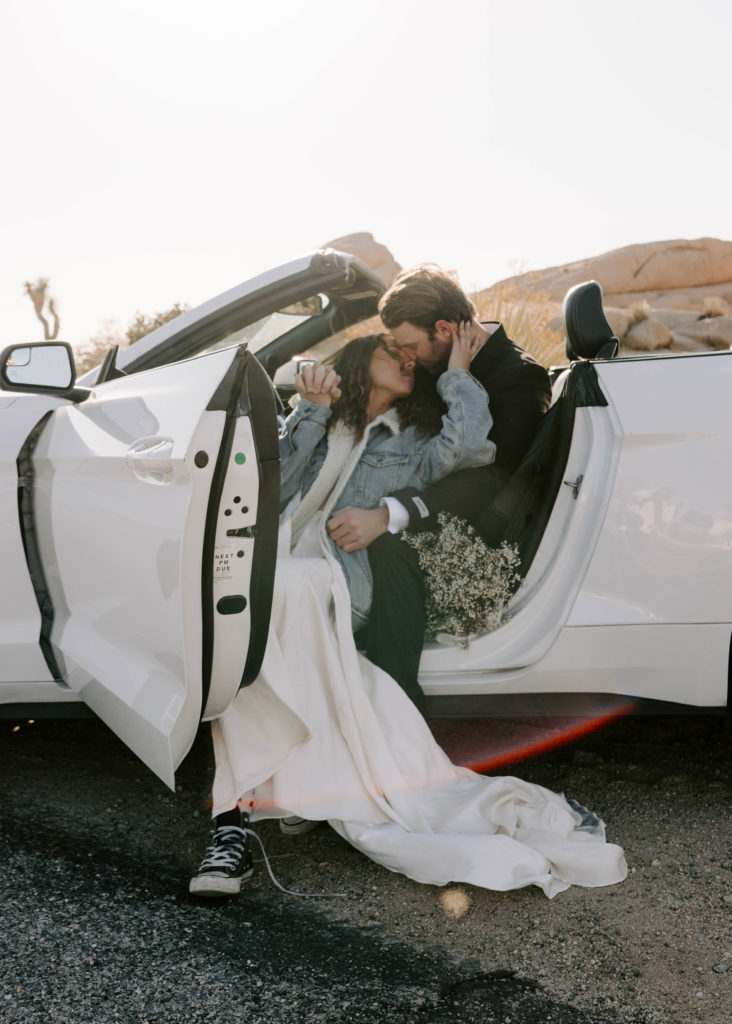 Bride and groom almost kissing while sitting in a car.