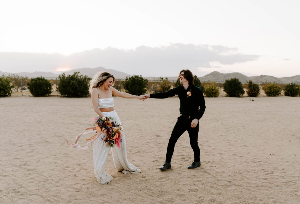 Bride and groom dancing in the desert after their wedding.