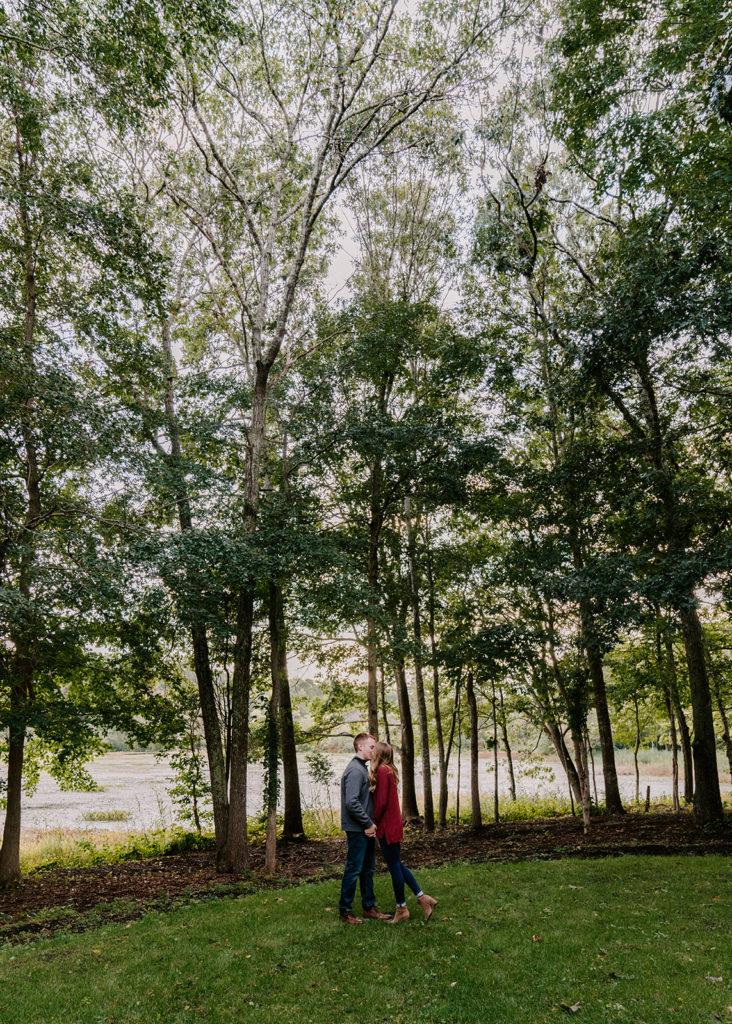 Couple kissing in woods.