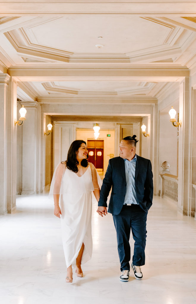 Couple walking through halls of San Francisco City Hall.
