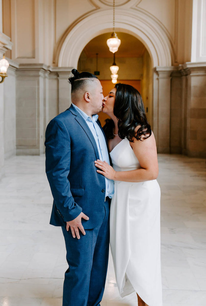 Couple kissing in San Francisco City Hall after their wedding.