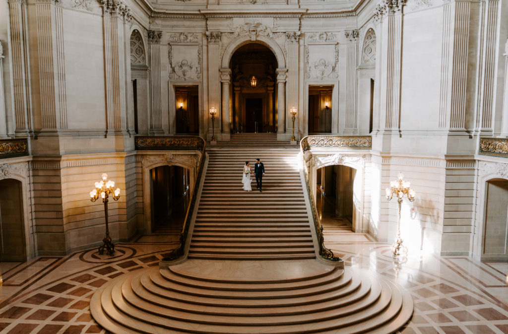 Couple walking down stairs in SF City Hall.