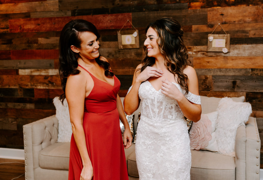 sister and bride smiling at one another
