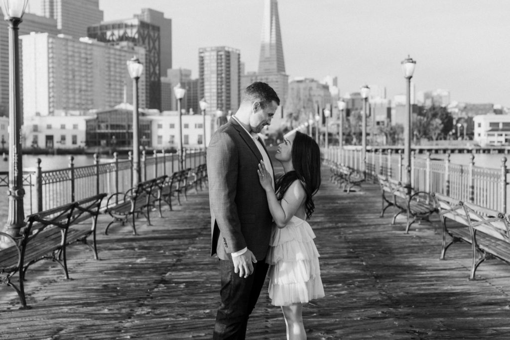 couple smiling at pier 7 in san francisco.