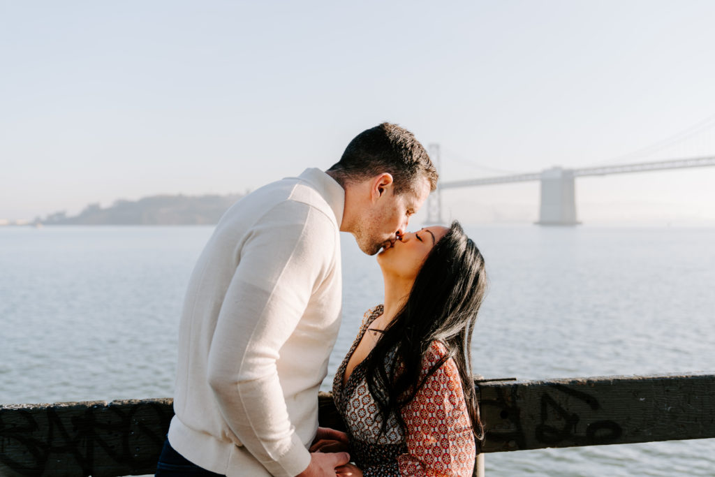 Couple kissing at the Bay Bridge.