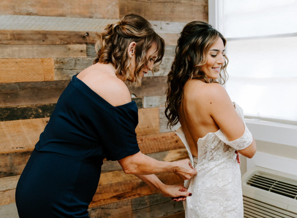 mom zipping bride's dress