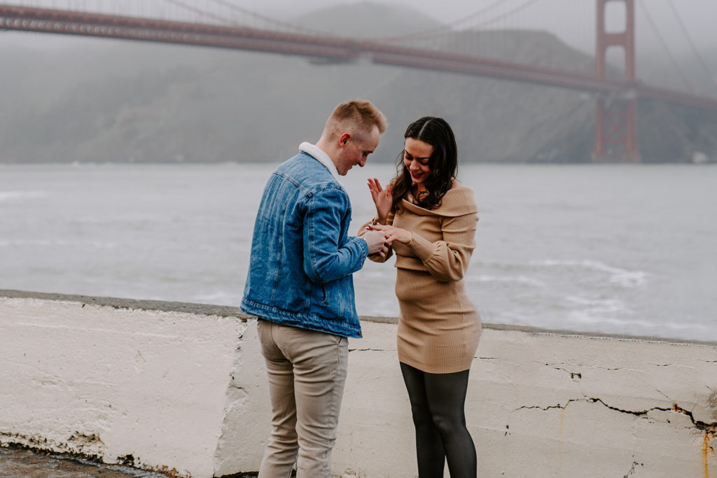 man putting engagement ring on