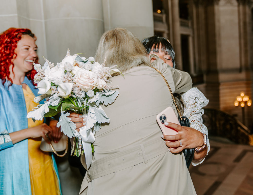 bride hugging groom's mom after getting married