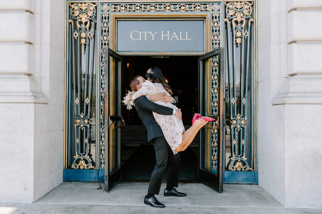 couple kissing outside of san francisco city hall