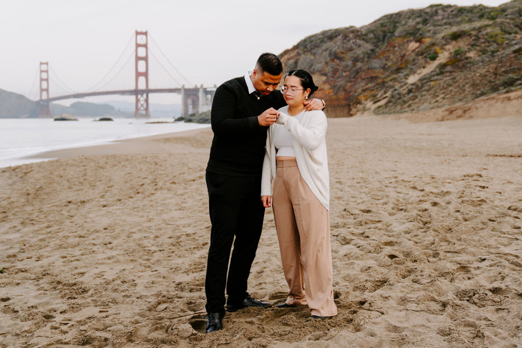 couple looking at engagement after baker beach proposal