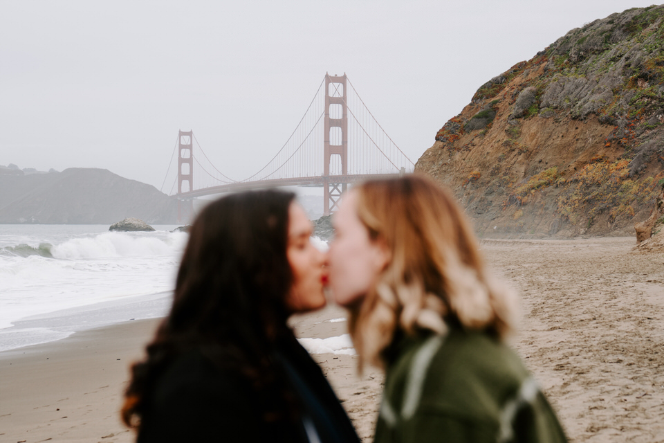 couple kissing with a view of the golden gate bridge