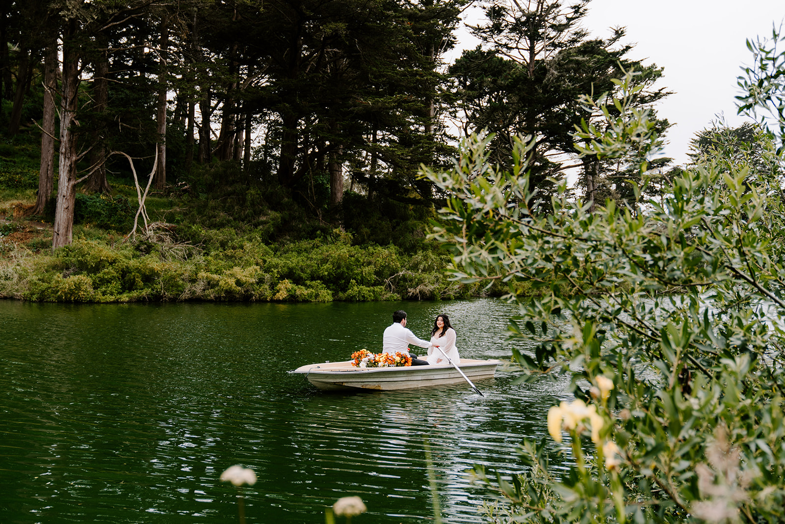 Couple rowing boat during Golden Gate Park engagement photos at Stow Lake.
