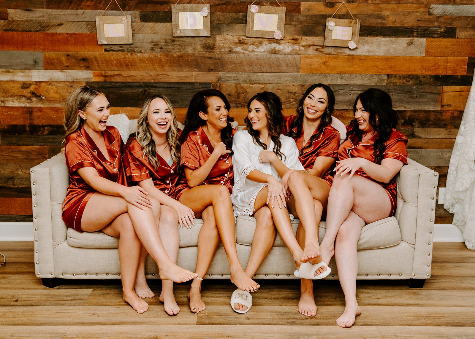 bridal party laughing on a couch during getting ready photos.